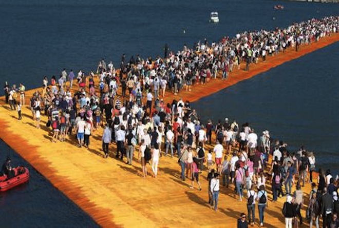 People walk the 'The Floating Piers' by  Bulgarian artists Christo and Jeanne-Claude on Lake Iseo during the opening of the art work near Sulzano, northern Italy, 18 June 2016. The 'Floating Piers' with their bright orange covers will be open until 03 July and will connect the two towns Sulzano and Monte Isola.  ANSA/FILIPPO VENEZIA